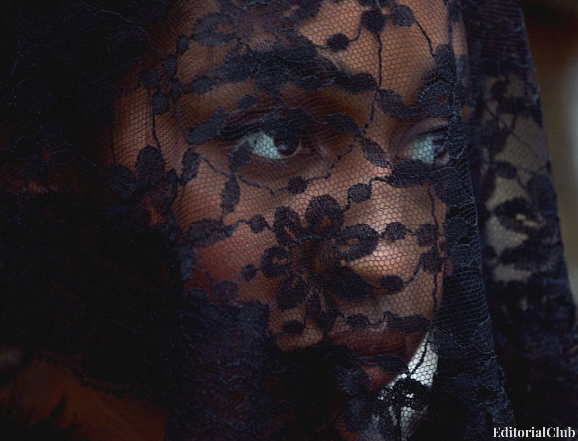 Close-up of Ayo Edebiri behind a sheer black lace veil, capturing a mysterious and dramatic mood for W Magazine.