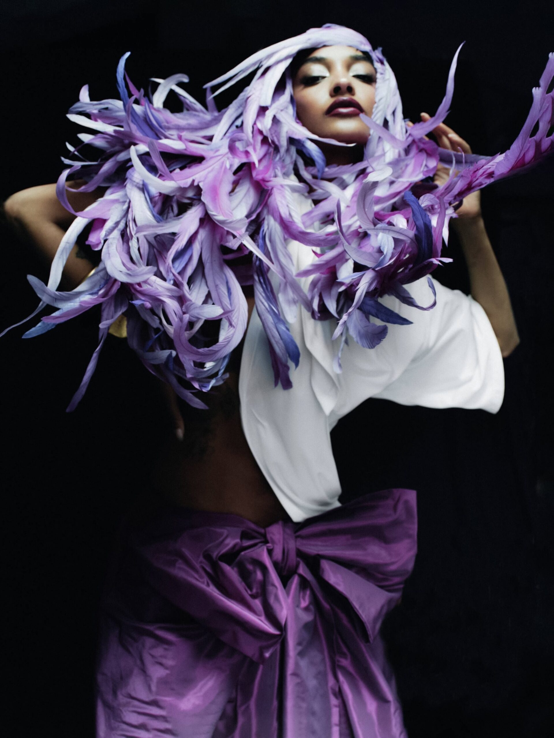 Jourdan Dunn styled in a dramatic white and purple feathered headdress with a voluminous purple skirt for Harper’s Bazaar España editorial.