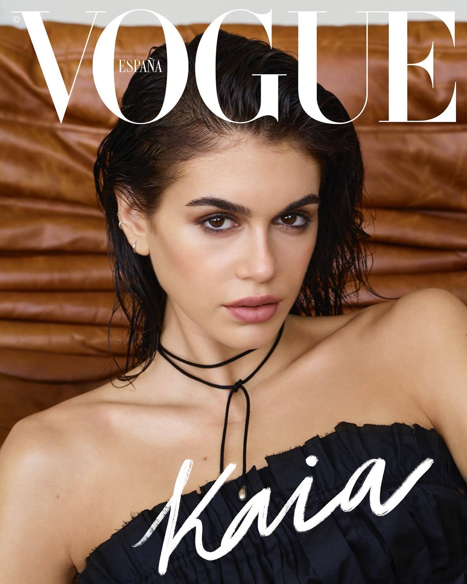Kaia Gerber on the June 2025 cover of Vogue Spain, styled in a strapless black dress with wet hair look