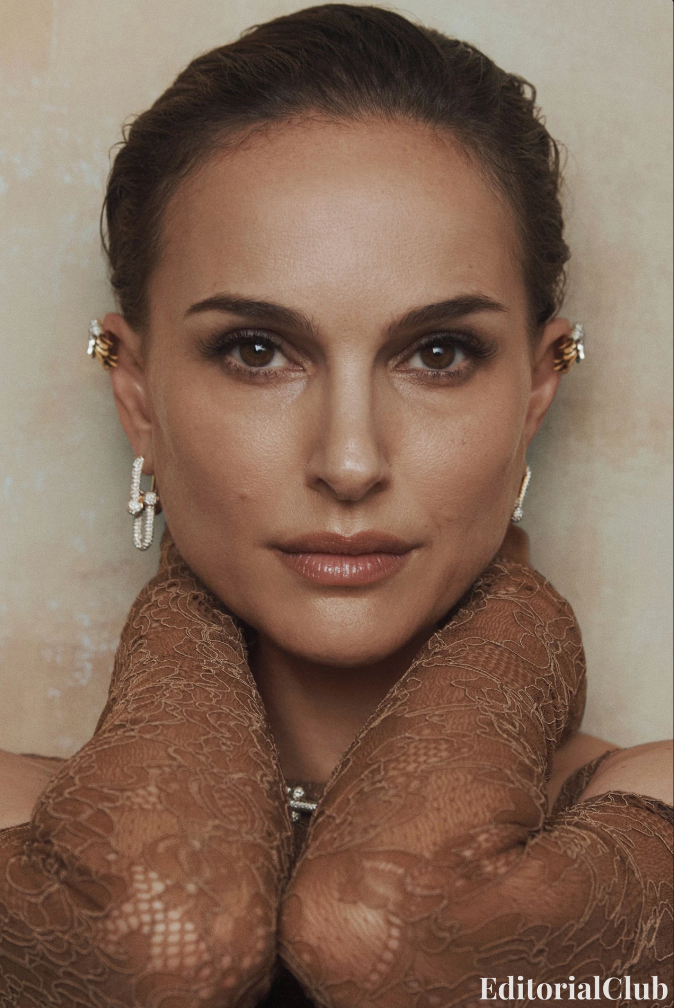 Close-up portrait of Natalie Portman wearing gold earrings and lace gloves, styled in neutral tones for Vogue Australia May 2025 editorial