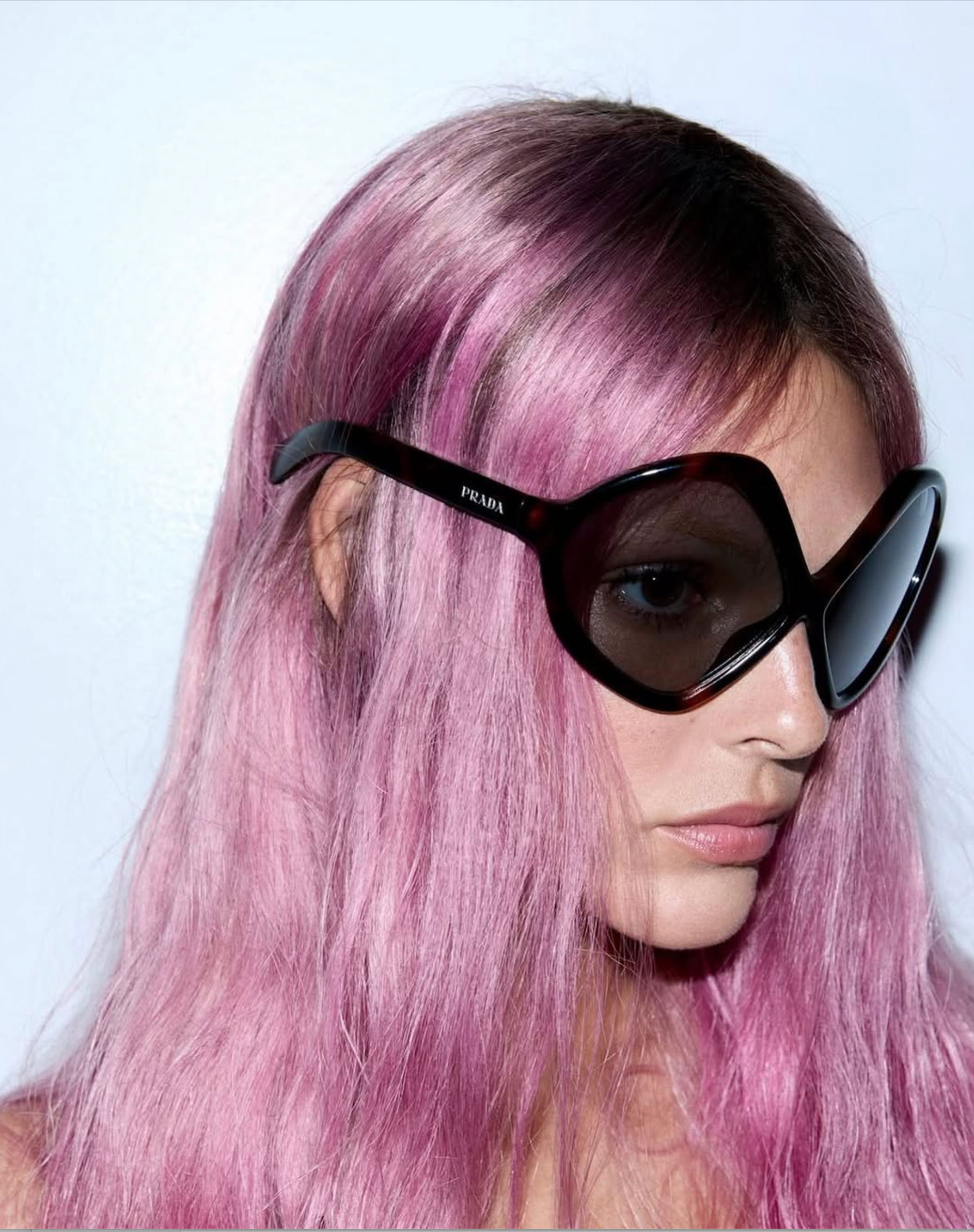 Close-up of Vittoria Ceretti with long pink hair wearing oversized Prada sunglasses, photographed for Vogue France April 2025.