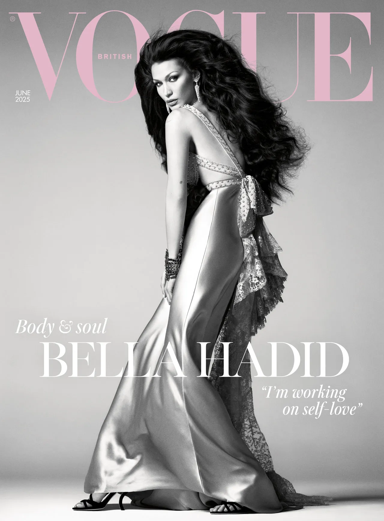 Bella Hadid poses in a satin gown on the British Vogue June 2025 cover, channeling vintage glamour with voluminous hair and bold styling.