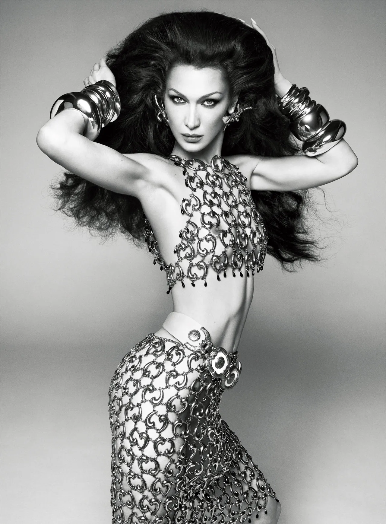 Bella Hadid in a bold chain-metal top and skirt ensemble, flaunting a sculptural silhouette for British Vogue's June 2025 issue.