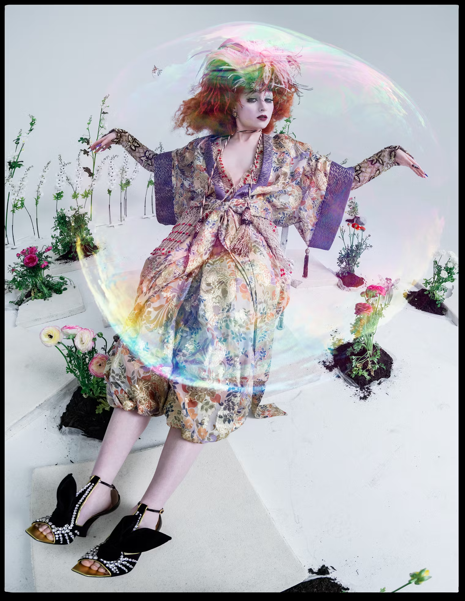 Surrounded by flowers and captured mid-motion inside a giant soap bubble, Chappell Roan wears a kimono-inspired metallic ensemble with feathers – W Magazine May 2025 editorial.