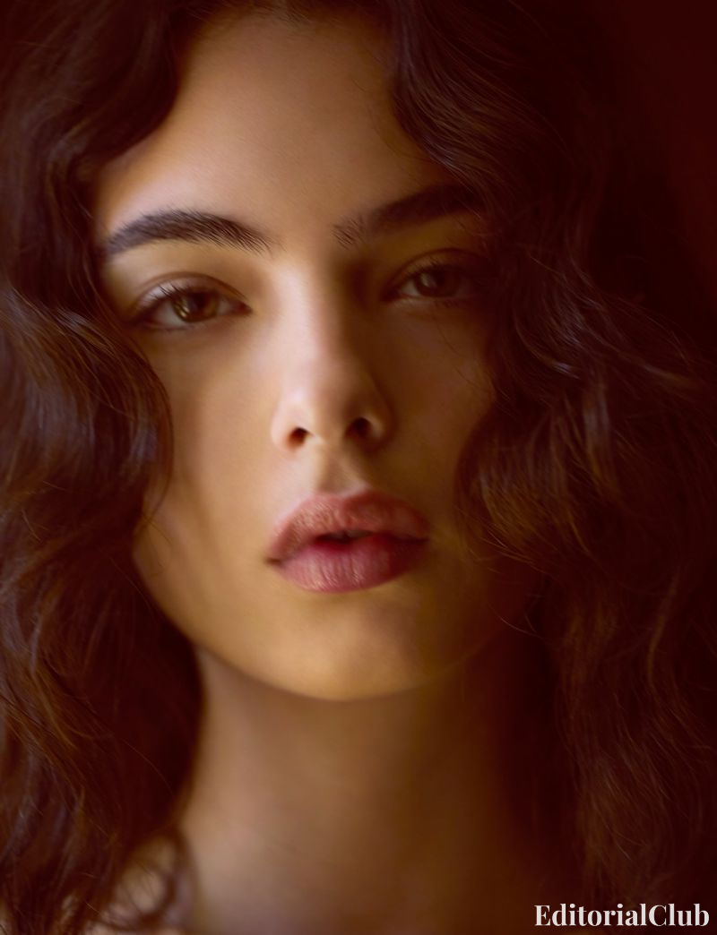 Close-up portrait of Deva Cassel with natural makeup and wavy hair, photographed in warm indoor light – Elle France