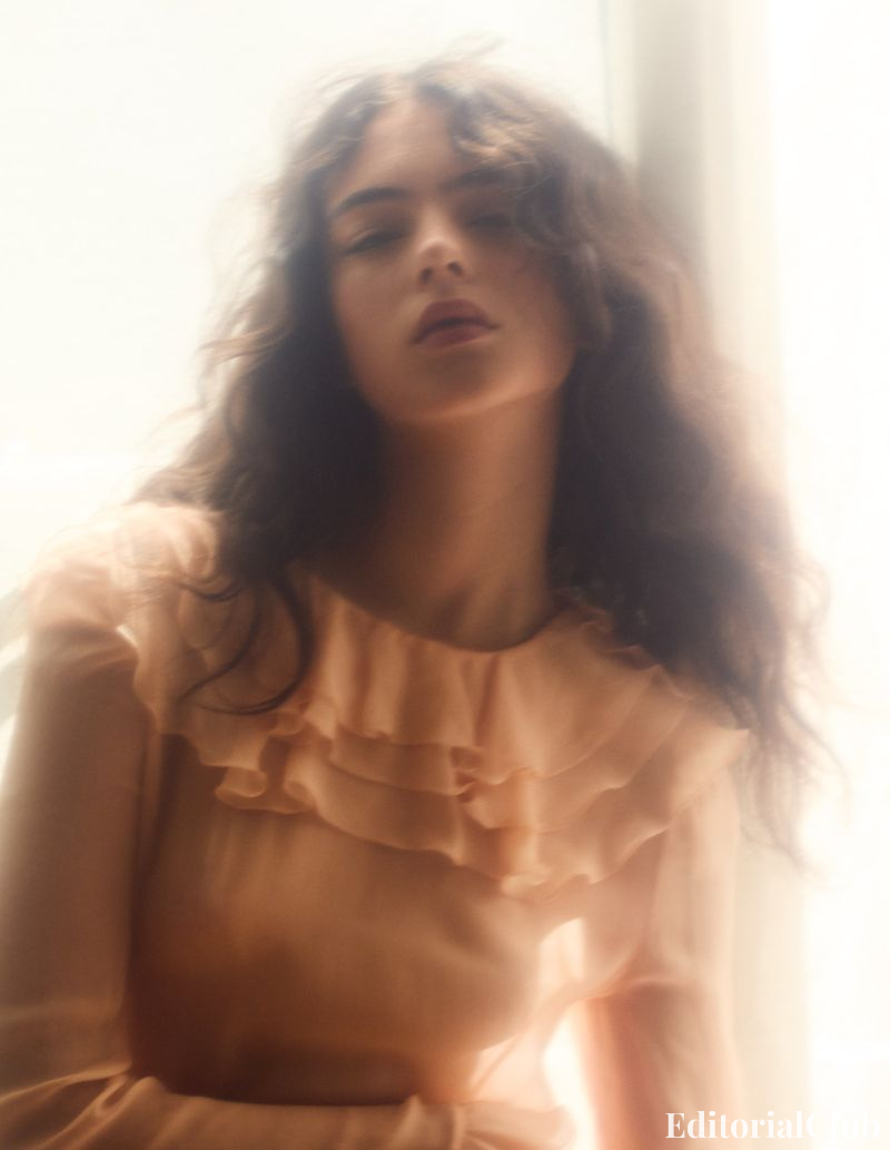 Deva Cassel in soft-focus peach dress with ruffled neckline, posing by a sunlit window – Elle France editorial
