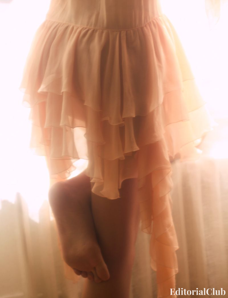 Close-up of Deva Cassel's legs and ruffled peach dress hem with backlit glow – Elle France Summer feature