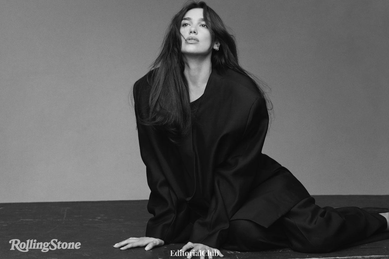 Dua Lipa in a monochrome portrait with windswept hair and oversized coat for Rolling Stone