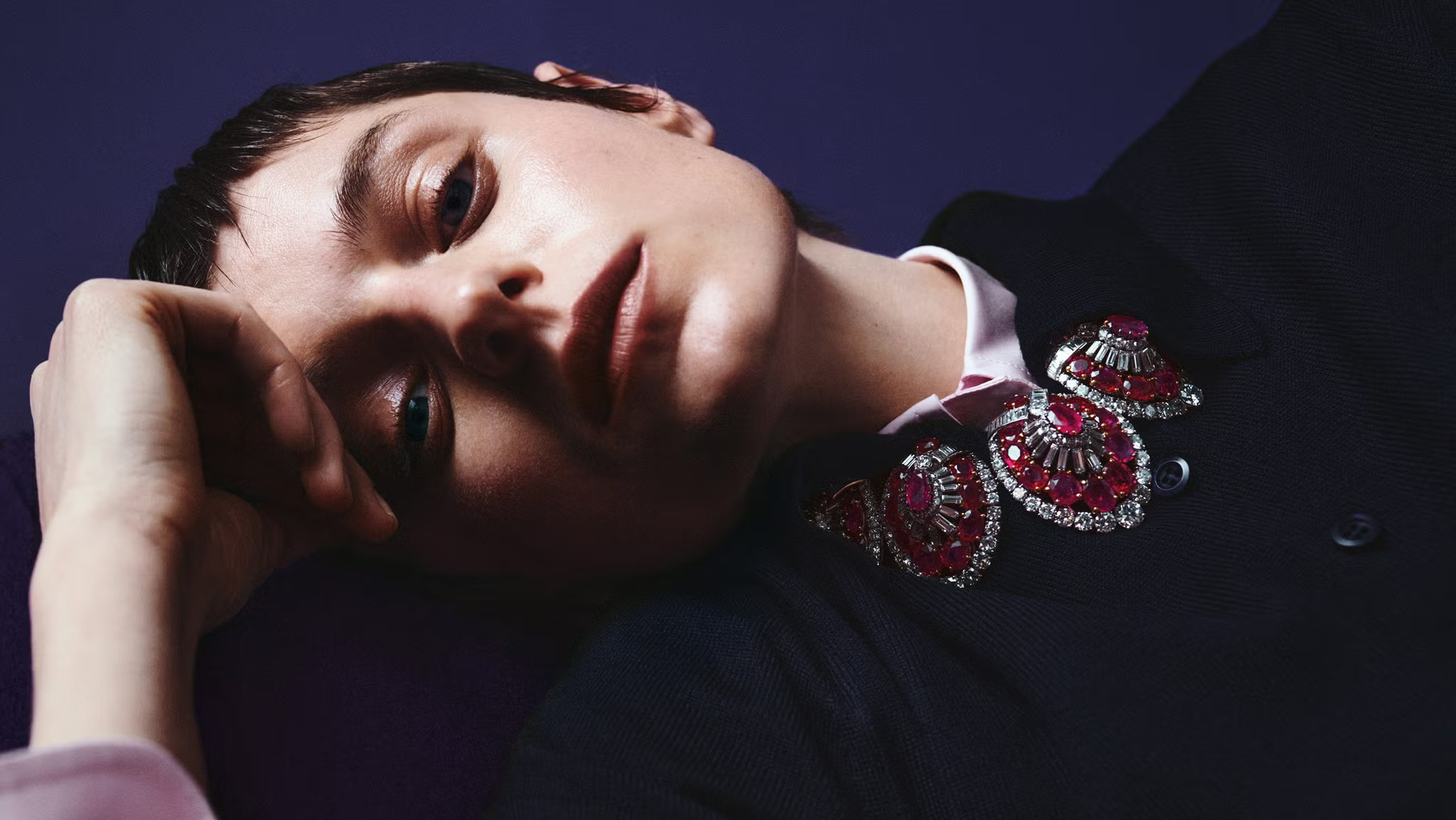 Dramatic close-up of Emma Corrin showcasing a jeweled red and silver embellished collar for ELLE UK fashion spread