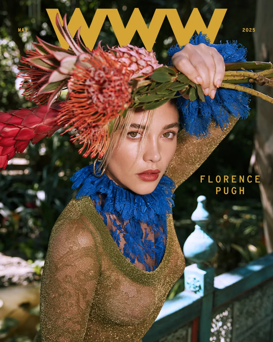 Florence Pugh on the May 2025 cover of Who What Wear, wearing a metallic gold dress with a cobalt blue lace neckline and a dramatic floral headpiece.