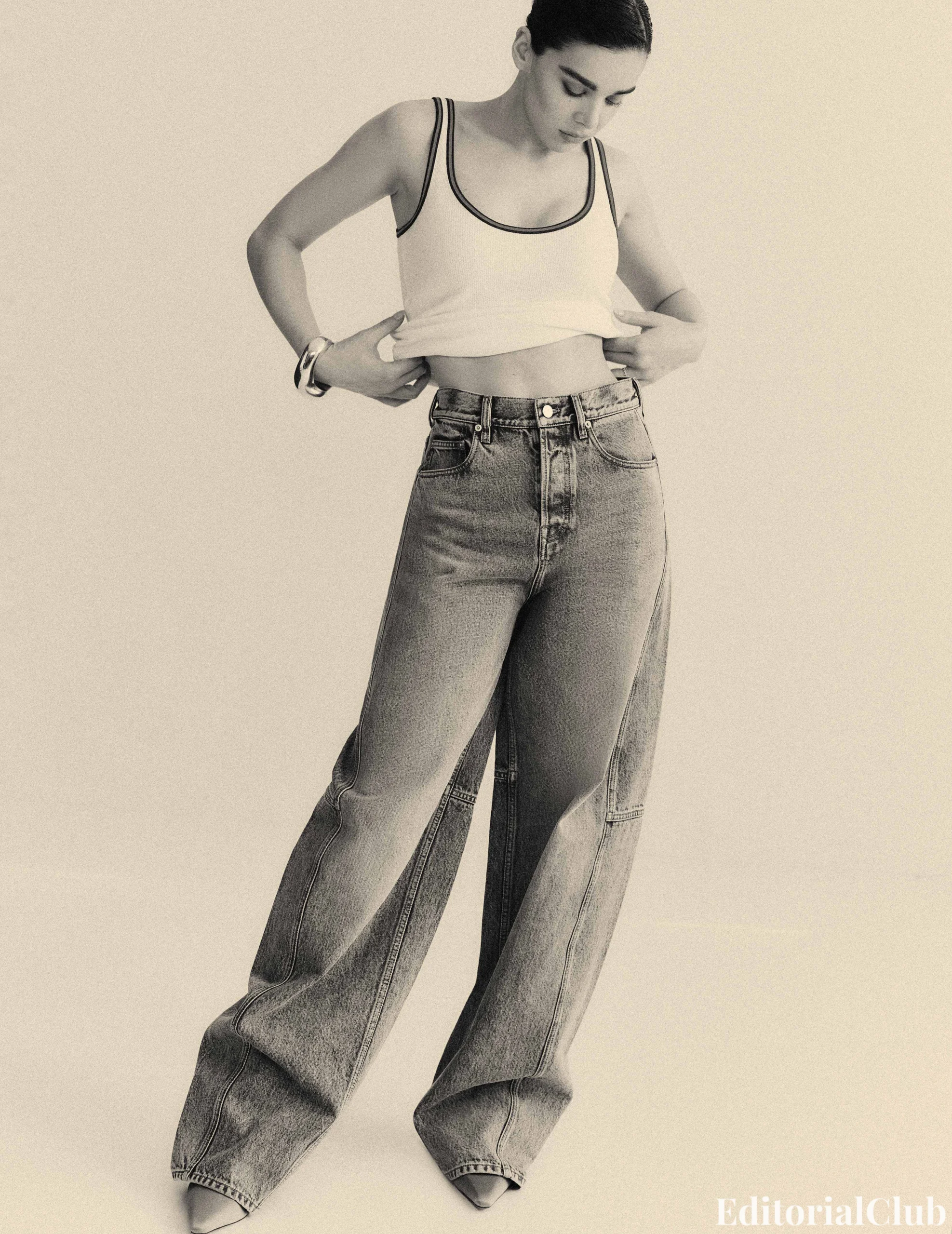 Hailee Steinfeld in a casual tank top and ultra-wide jeans for her Flaunt Magazine March 2025 editorial.
