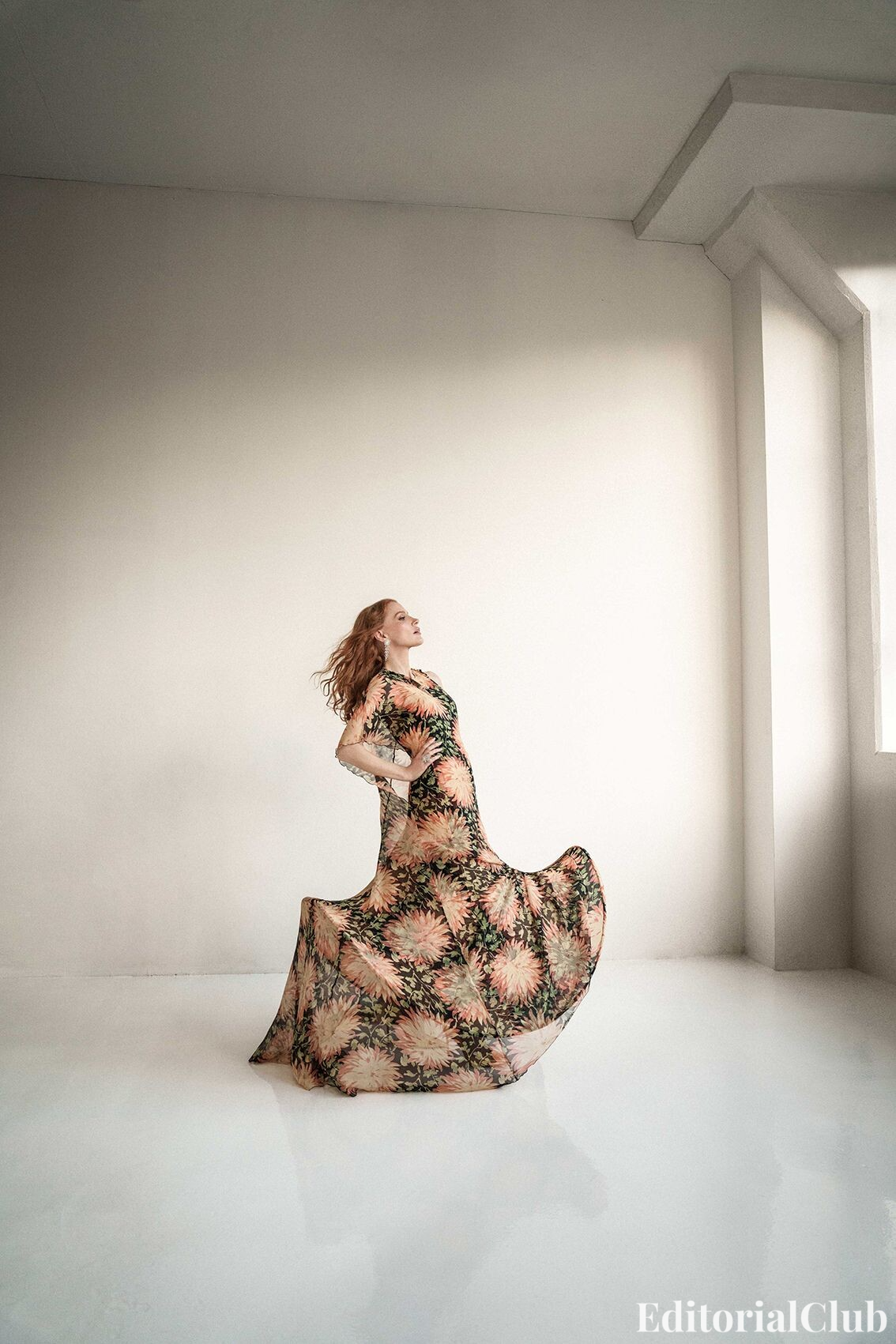 Jessica Chastain in a flowing floral gown posing dramatically in a minimalist studio for ELLE Spain April 2025