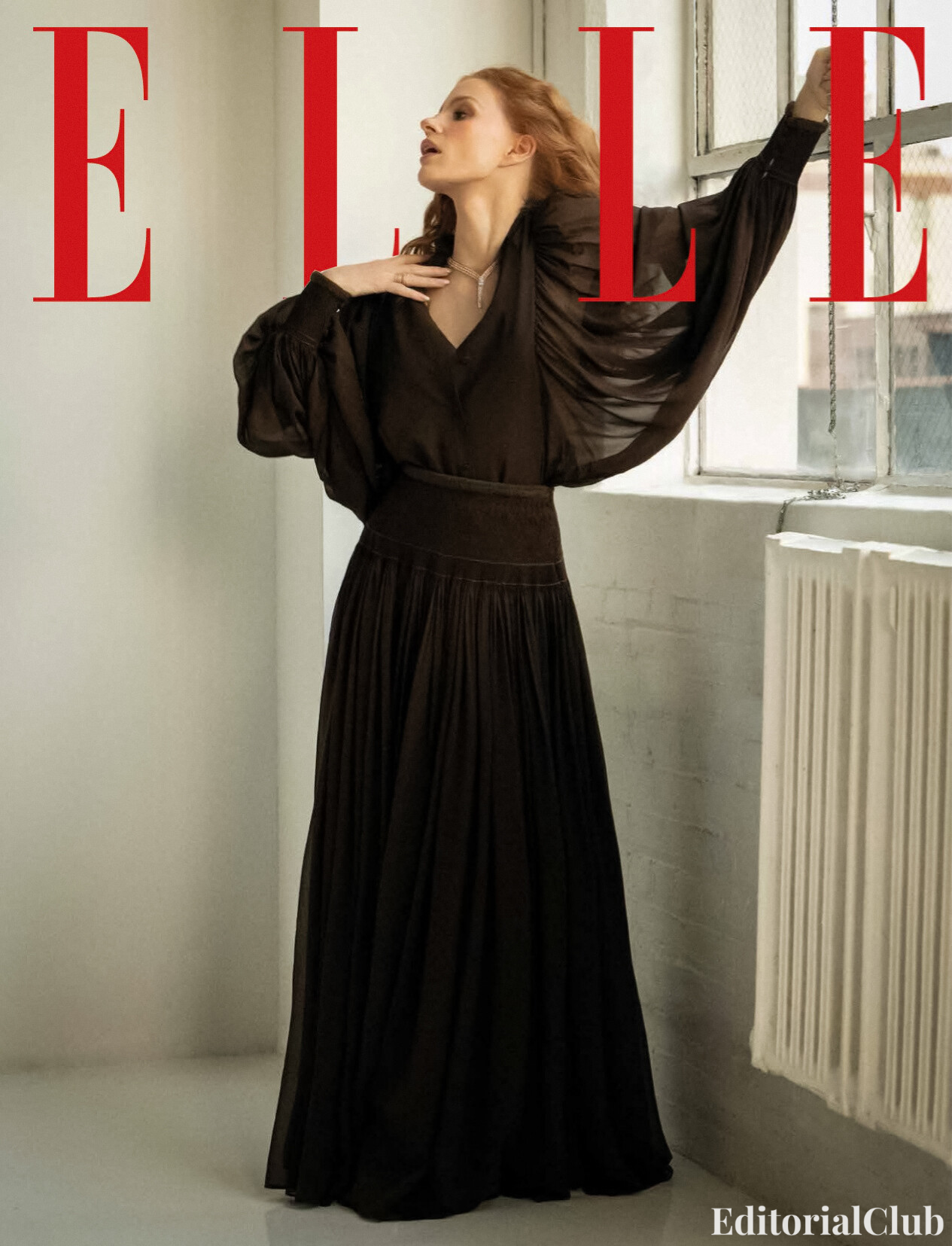 Jessica Chastain poses elegantly by a window in a flowing black gown for the ELLE Spain April 2025 magazine cover.