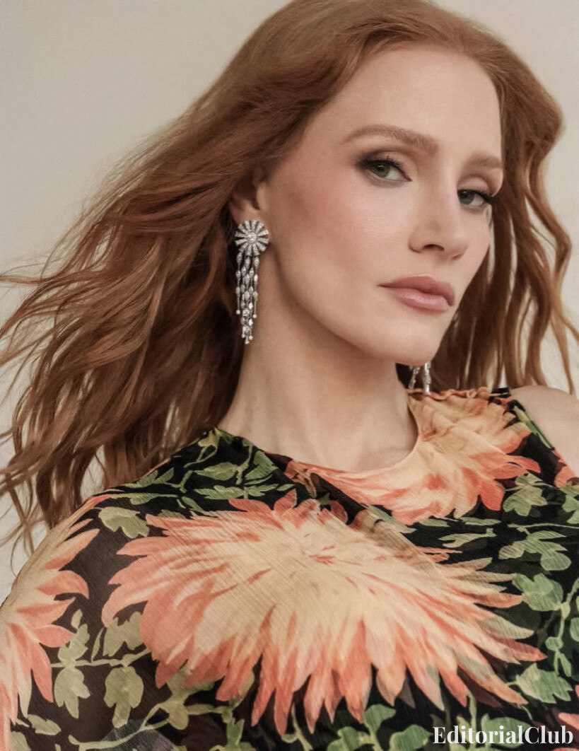 Close-up of Jessica Chastain wearing a bold floral dress and dazzling chandelier earrings in ELLE Spain April 2025 editorial.