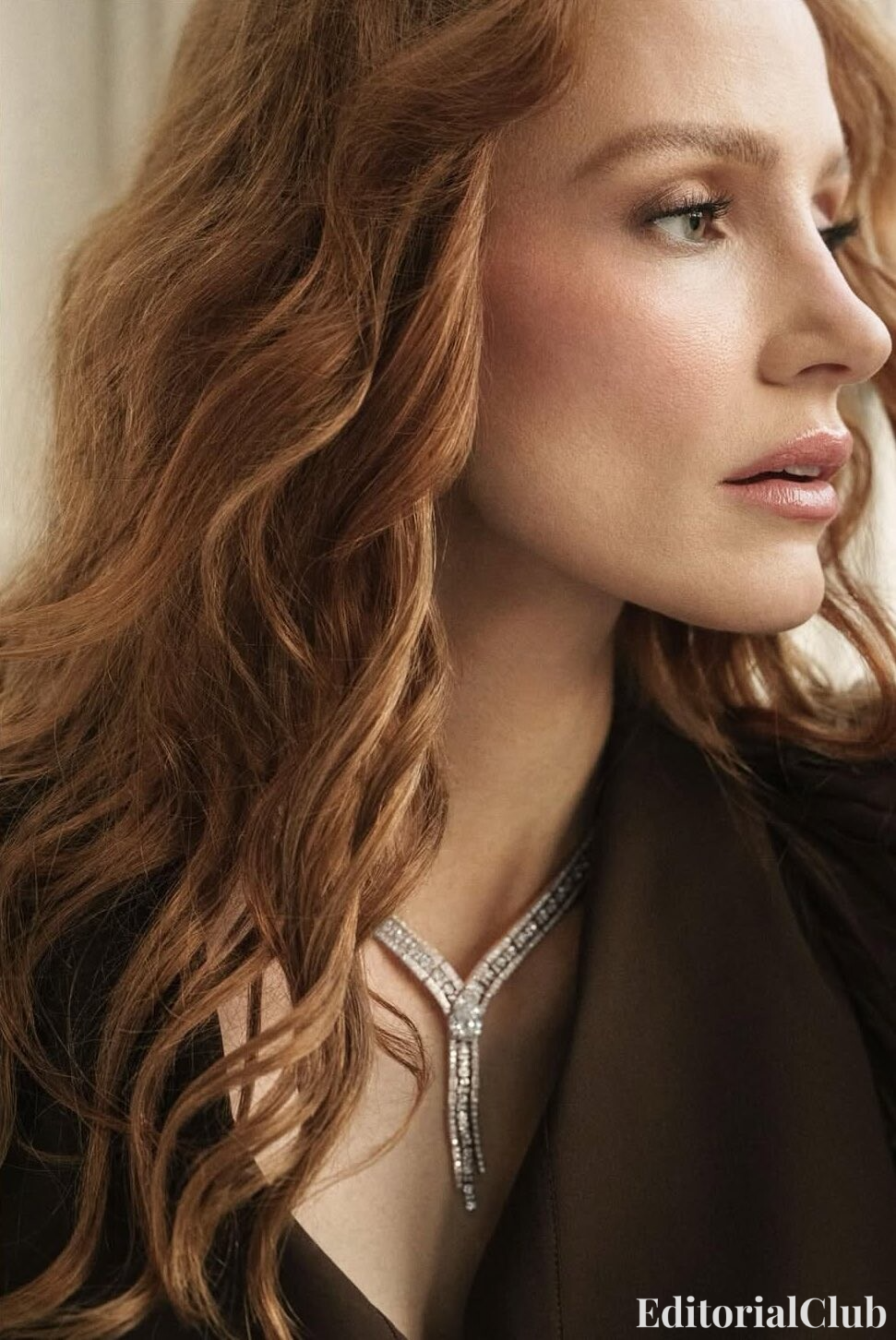 Jessica Chastain profile close-up with voluminous red waves and diamond necklace – Elle Spain