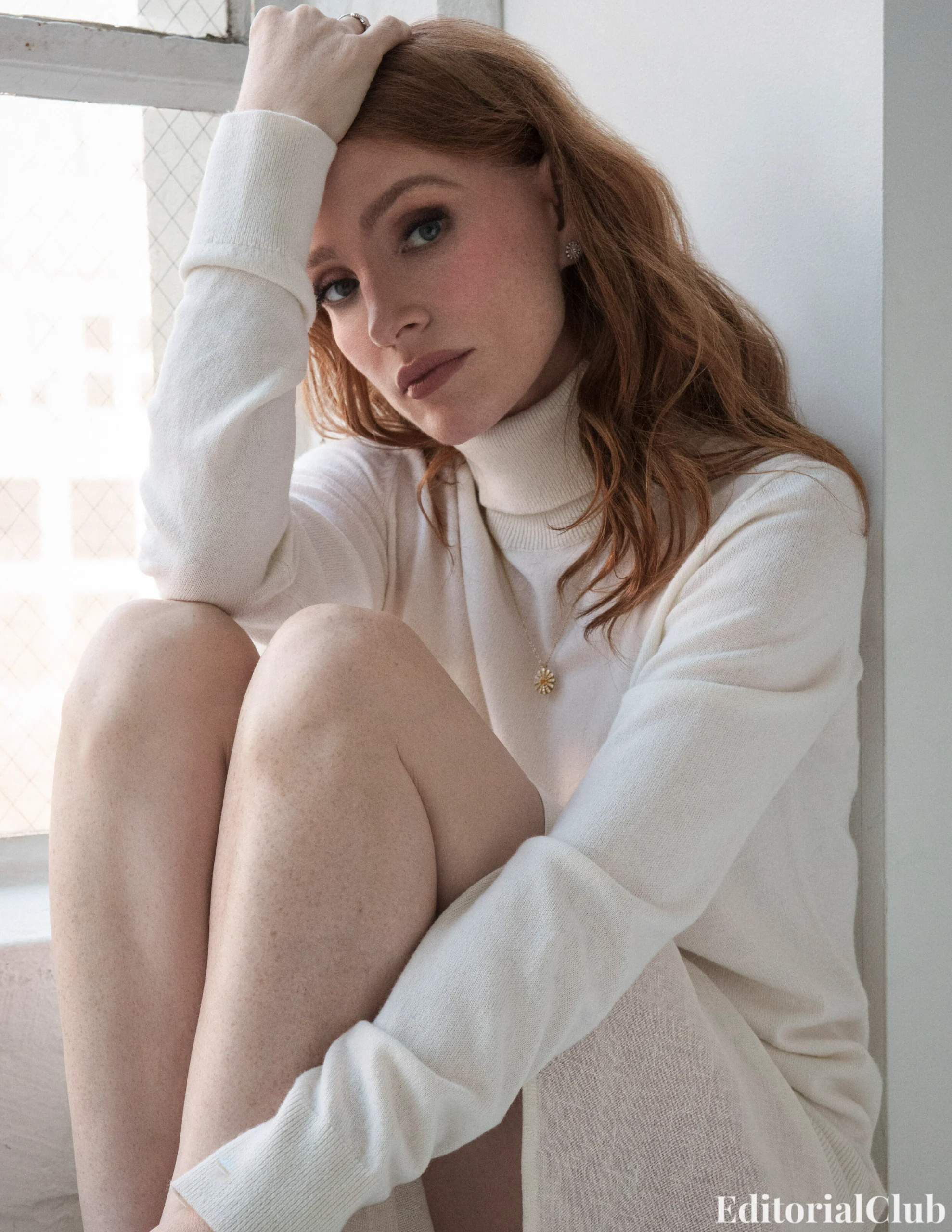 Jessica Chastain sitting by a window in a cozy cream turtleneck dress for ELLE Spain April 2025 shoot