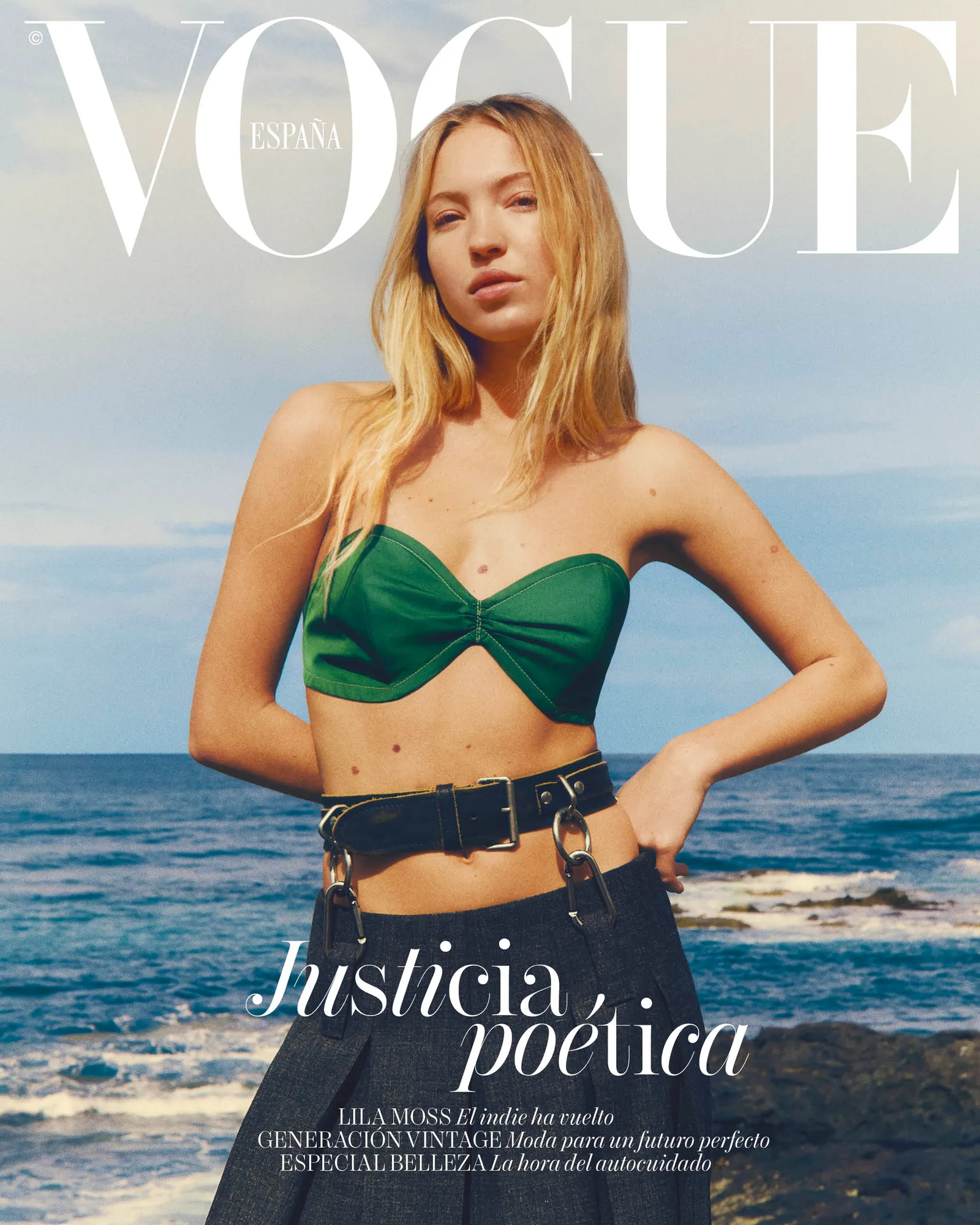 Lila Moss on the cover of Vogue Spain April 2025, wearing a green strapless top and high-waisted pants by the ocean.