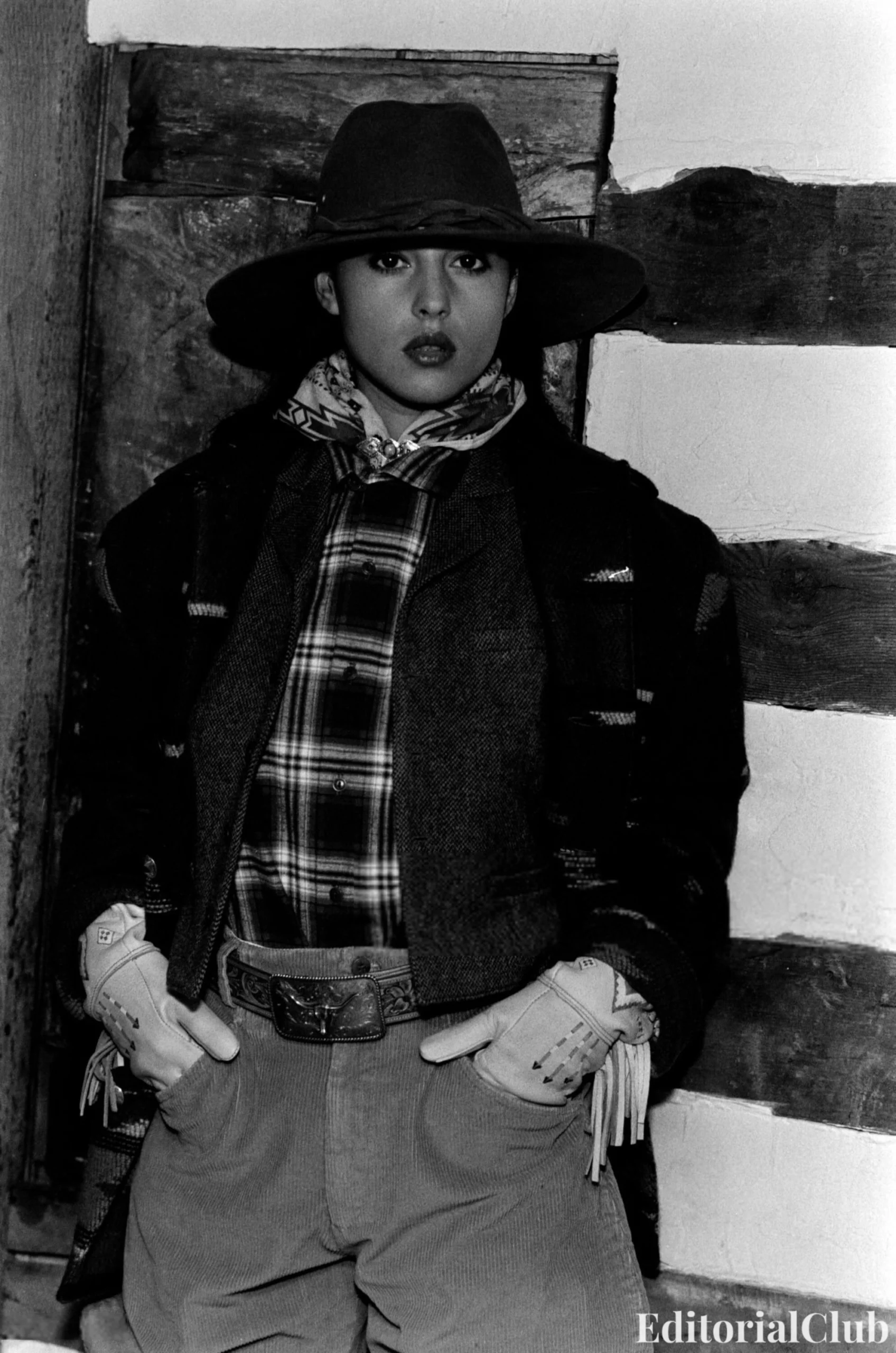 Monica Bellucci in Ralph Lauren Fall 1989, wearing Western-inspired layers including a plaid shirt, embroidered gloves, wide-brim hat, and belted corduroy trousers, and a tailored look with a printed knit vest over a collared blouse styled with a belt and shoulder bag.