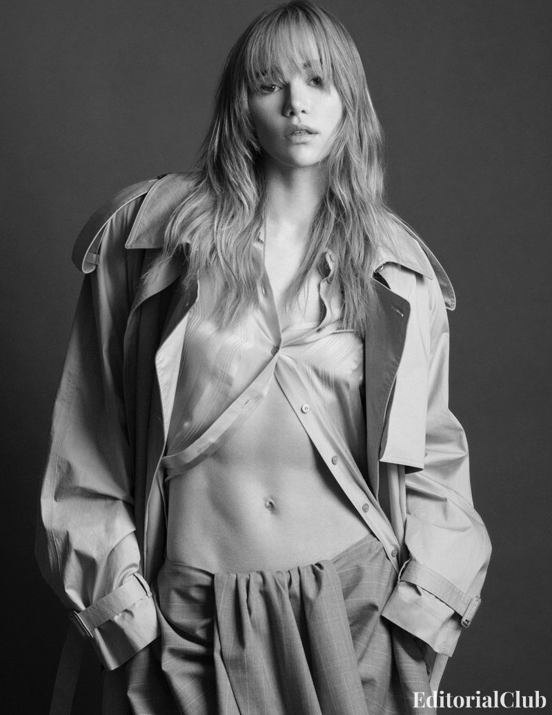 Black and white fashion portrait of Suki Waterhouse in unbuttoned blouse and trench coat – Elle Spain March 2025