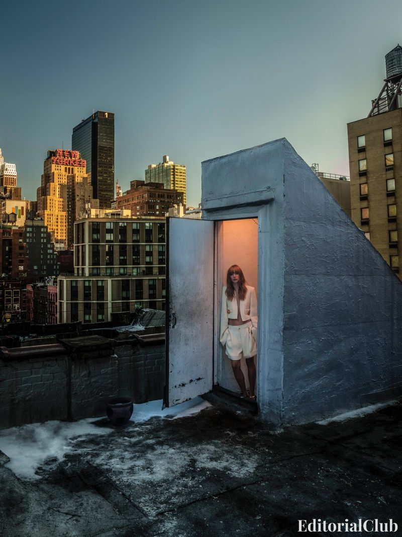 Suki Waterhouse standing in a rooftop doorway overlooking New York City skyline at dusk – Elle Spain March 2025 editorial