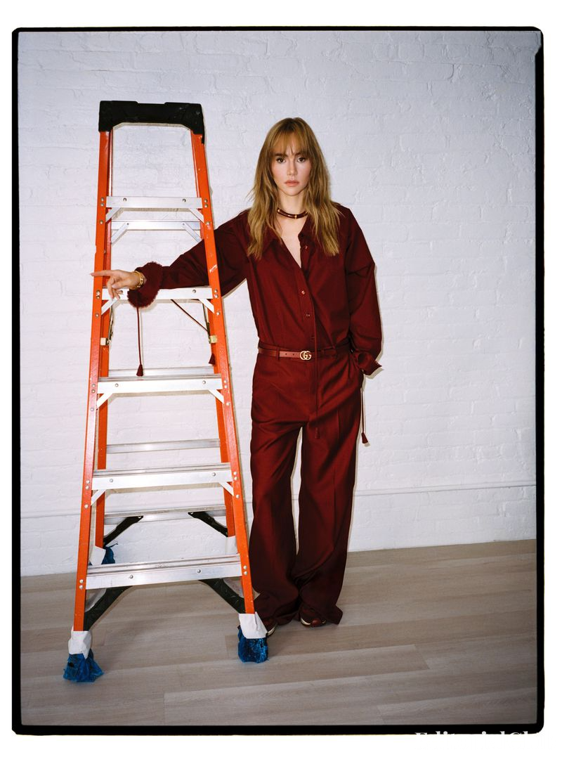 Suki Waterhouse leaning on orange ladder in red Gucci outfit – Elle Spain March 2025 photoshoot