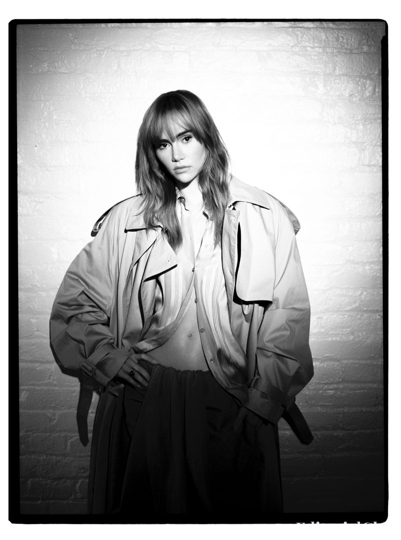 Dramatic black and white portrait of Suki Waterhouse in trench coat and wide-leg trousers – Elle Spain March 2025