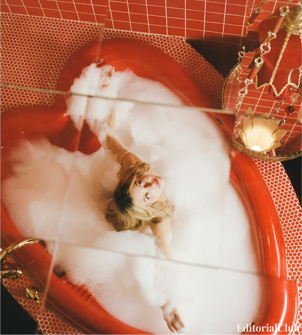 Sydney Sweeney posing in a luxurious heart-shaped red bathtub filled with bubbles for Cosmopolitan 2022 romantic editorial shoot.